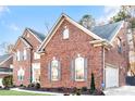 Side view of brick home with a well-manicured lawn, showcasing the garage and window designs at 16025 Agincourt Dr, Huntersville, NC 28078