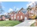 Brick home exterior with a long driveway, well-maintained lawn, mature trees, and a basketball hoop at 16025 Agincourt Dr, Huntersville, NC 28078