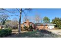 Quaint brick home with a chimney, mature trees, and a well-maintained front yard on a sunny day at 2010 Rankin Rd, Gastonia, NC 28056