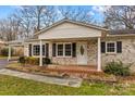 Inviting covered front porch with brick detailing and landscaping offering a charming entrance to the single-story home at 280 Linda St, Salisbury, NC 28146