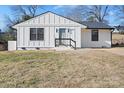 Charming white farmhouse exterior, featuring a gray front door and well-manicured lawn at 3020 Bellaire Dr, Charlotte, NC 28216