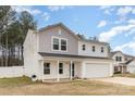 Charming two-story home with a covered porch, attached two car garage, and fenced-in yard at 310 Black Rock School Rd, Cherryville, NC 28021