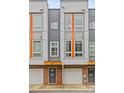 Close-up of a townhome showcasing a brick base, gray siding, and modern windows with orange accents at 3617 Vallette Ct, Charlotte, NC 28203
