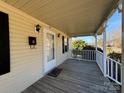 Inviting covered front porch with wood flooring and white railing, perfect for relaxing outdoors at 701 Eldorado St, Troy, NC 27371