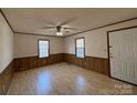 Spacious living room with laminate wood floors, natural light, and a ceiling fan at 701 Eldorado St, Troy, NC 27371