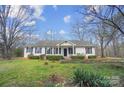 Inviting single-story house with black shutters, a walkway, and green lawn at 7921 Fairmont Dr, Waxhaw, NC 28173
