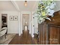 Elegant hallway with hardwood floors, white wainscoting, and a view into the dining room at 1211 Pinecrest Ave, Charlotte, NC 28205