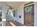 Inviting front porch with a cozy swing, ceiling fan, and charming wreath on the front door at 1211 Pinecrest Ave, Charlotte, NC 28205