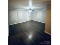 Bright living room with wood-look floors, fresh paint, two large windows, and a stylish ceiling fan at 128 N Oak St, Salisbury, NC 28146