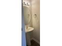 Small bathroom with pedestal sink, round mirror, and dark wood vanity at 1606 Lincoln Dr, Shelby, NC 28152