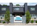 NoDa Landing Condominiums featuring a sign and well-maintained landscaping at 2000 Patio Ct # 101, Charlotte, NC 28205