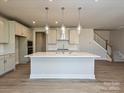 Modern kitchen with island, stainless steel appliances, and hardwood floors at 207 Halemarge Drive Dr, Belmont, NC 28012