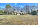 Well-kept one story house with a large front yard and a carport on a sunny day at 2100 Sunderland Pl, Charlotte, NC 28211