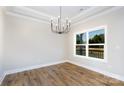 Bright dining area featuring wood flooring, a modern chandelier, and a large window with backyard views at 2364 Valley Meadows Dr, York, SC 29745