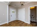 Bright foyer with wood flooring, a modern light fixture, and a view of the powder room at 2364 Valley Meadows Dr, York, SC 29745