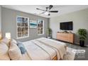 A spacious bedroom with a ceiling fan, two windows, light gray walls, and a comfy rug at 2650 Whisper Ridge Ln, Matthews, NC 28105