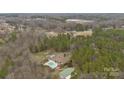 Expansive aerial view showcasing a beautiful home, pool, and surrounding wooded landscape for privacy at 47997 Wagoner Rd, Richfield, NC 28137