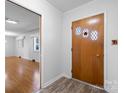 Foyer featuring brown vinyl floors, paneled door, and open view to living area at 63 Wagner Rd, Taylorsville, NC 28681