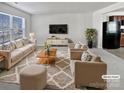 Spacious living room featuring beige sofas, a coffee table, and a large TV at 6324 Cutwater Cir, Charlotte, NC 28269