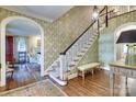 Grand foyer with beautiful staircase, hardwood floors and decorative wallpaper at 641 Museum Dr, Charlotte, NC 28207