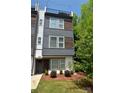 Stylish townhouse with a combination of painted brick, gray panels, and wooden accents with a cozy front yard at 7020 Loso Commons Way, Charlotte, NC 28217