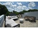 Outdoor roof deck featuring comfortable seating, string lights, and a dining area, perfect for entertaining at 7020 Loso Commons Way, Charlotte, NC 28217