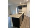 Modern kitchen with granite countertop island, stainless steel appliances, and dark cabinets at 917 W Sumter St, Shelby, NC 28150