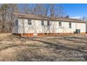 View of the rear of a single story home with light siding and a level lawn at 115 Winterhaven Rd, Taylorsville, NC 28681