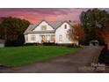 Beautiful exterior view of a modern farmhouse with a long driveway and well-manicured lawn surrounded by mature trees at 117 Yellow Jacket Cir, Mooresville, NC 28117