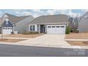 Well-presented home with gray siding, a two-car garage, and a clean driveway, nestled within a friendly neighborhood setting at 12619 Belmont Mansion Dr, Charlotte, NC 28273