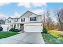 Charming two-story home with a two-car garage, stone accents, manicured lawn, and professional landscaping at 129 Woodbridge Cir, Mount Holly, NC 28120