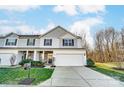 Charming two-story home with a two-car garage and manicured lawn with stone accents and professional landscaping at 129 Woodbridge Cir, Mount Holly, NC 28120