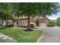 Charming brick home with a well-manicured lawn, mature trees, and a three-car garage at 14507 Old Vermillion Dr, Huntersville, NC 28078