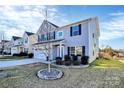 A beautifully landscaped front yard with a young tree enhances the curb appeal at 1686 Scarbrough Sw Cir, Concord, NC 28025