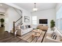 Bright living room features stylish decor, hardwood floors and staircase to the second level at 1686 Scarbrough Sw Cir, Concord, NC 28025