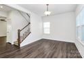 Bright living room with stylish hardwood floors and staircase to the second level at 1686 Scarbrough Sw Cir, Concord, NC 28025