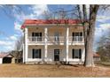 A lovely white two-story home with a red roof and double porches, complete with black shutters at 202 Deitz Rd, Statesville, NC 28625