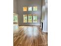 Bright living room with hardwood floors, fireplace, and many windows offering outdoor views at 2418 Lexington Approach Dr, Charlotte, NC 28262