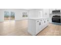 Modern kitchen featuring white cabinets, stainless steel appliances, and a spacious island with countertop seating at 3722 Thompson St, Newton, NC 28658