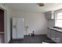 This kitchen features a white refrigerator, grey cabinets, and dark flooring at 529 Gage St, Chester, SC 29706