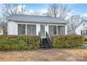 Home exterior featuring trimmed hedges, siding, large windows, and a small staircase at 63 3Rd Nw St, Concord, NC 28027