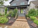 Inviting front porch with stone accents, a bright green front door, and well-manicured landscaping at 817 Digby Rd, Rock Hill, SC 29730