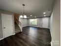 Spacious living room with dark hardwood floors and a staircase at 9103 Exbury Ct, Charlotte, NC 28269