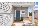 Charming entryway with blue front door, welcome mat, brick accents, and vertical siding details at 110 Shay Crossing Rd # 1P, Salisbury, NC 28144