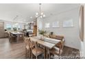 Inviting dining room showcasing modern lighting, wood floors, and an adjacent open-concept kitchen at 112 Stonewater Dr # 33P, Red Cross, NC 28129