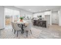 Bright, open kitchen and dining area featuring white cabinets, stainless appliances, and light gray plank floors at 120 Random Dr, Salisbury, NC 28147