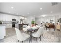 Open-concept kitchen and dining area with modern white cabinetry and stylish furnishings, and light gray plank floors at 120 Random Dr, Salisbury, NC 28147
