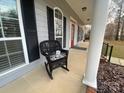 Inviting front porch showcasing a rocking chair, grey siding, and white columns at 359 Magness Rd, Shelby, NC 28150