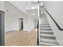 Bright foyer featuring modern hardwood floors, staircase with black handrail, and contemporary light fixtures at 4630 Hannah Dr, Rock Hill, SC 29732