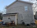 Shows a view of the backyard with siding and various chairs, tables, and other miscellaneous items at 609 Billingsley Rd, Charlotte, NC 28211